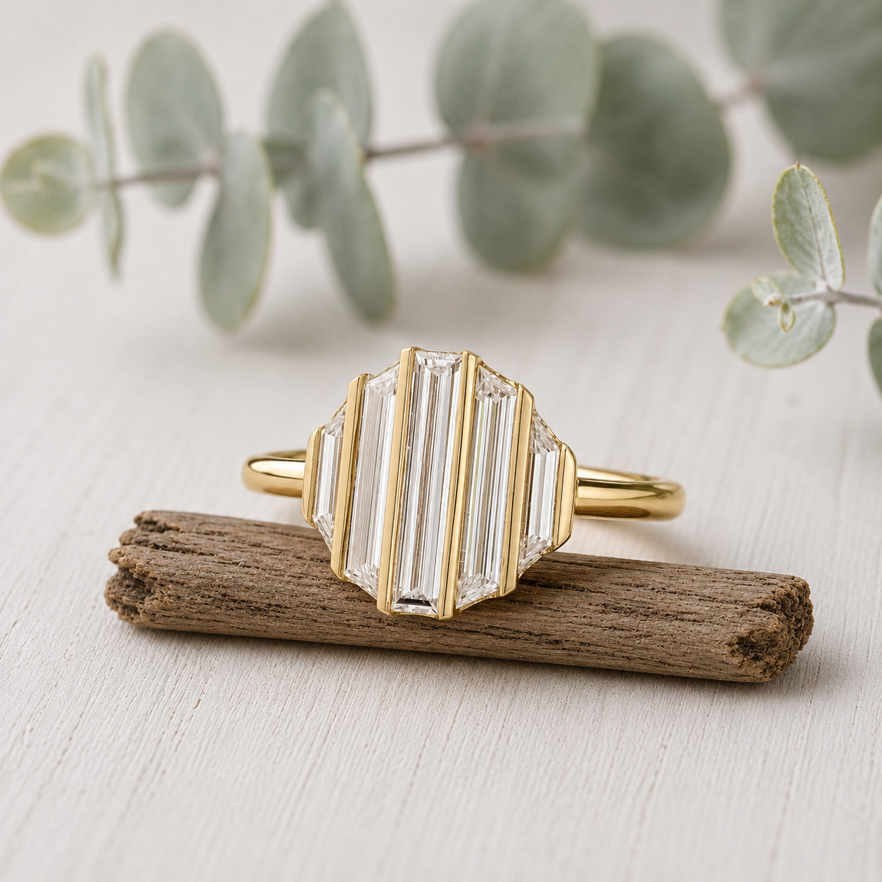 Baguette Diamond Engagement Ring featuring a lab-grown baguette cut diamond center stone with trapeze cut side diamonds in a geometric contemporary gold setting with a slim 1.7 mm band, designed as a modern minimalist engagement ring.