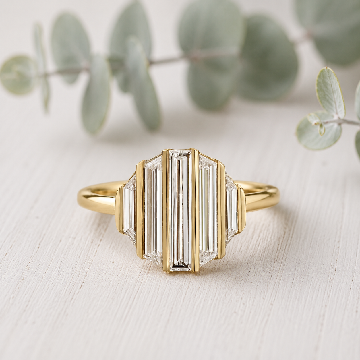 Baguette Diamond Engagement Ring featuring a lab-grown baguette cut diamond center stone with trapeze cut side diamonds in a geometric contemporary gold setting with a slim 1.7 mm band, designed as a modern minimalist engagement ring.