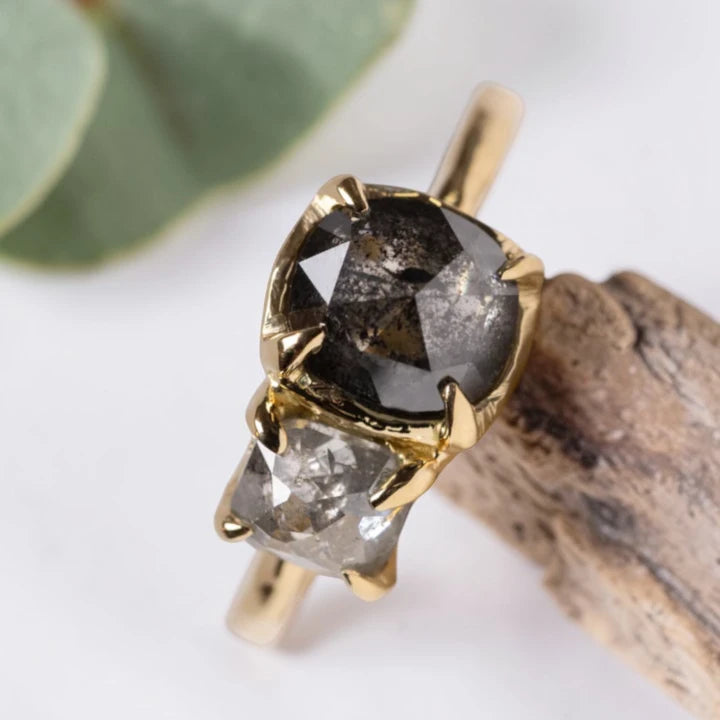 Cushion rose cut salt and pepper diamond two stone ring featuring a 1.80 CT center diamond and 0.65 CT companion diamond with natural inclusions, handcrafted on a minimalist straight band alternative engagement design.