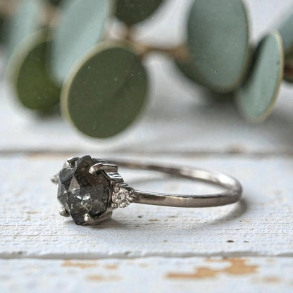 Hexagon diamond ring featuring a raw salt and pepper diamond center stone with natural organic inclusions, set in a handcrafted minimalist design with a clean modern band and geometric alternative engagement style.