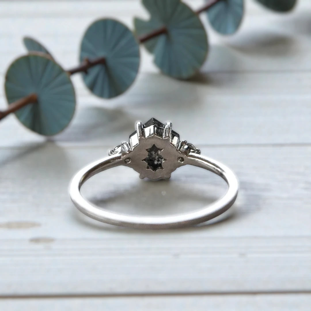 Hexagon diamond ring featuring a raw salt and pepper diamond center stone with natural organic inclusions, set in a handcrafted minimalist design with a clean modern band and geometric alternative engagement style.