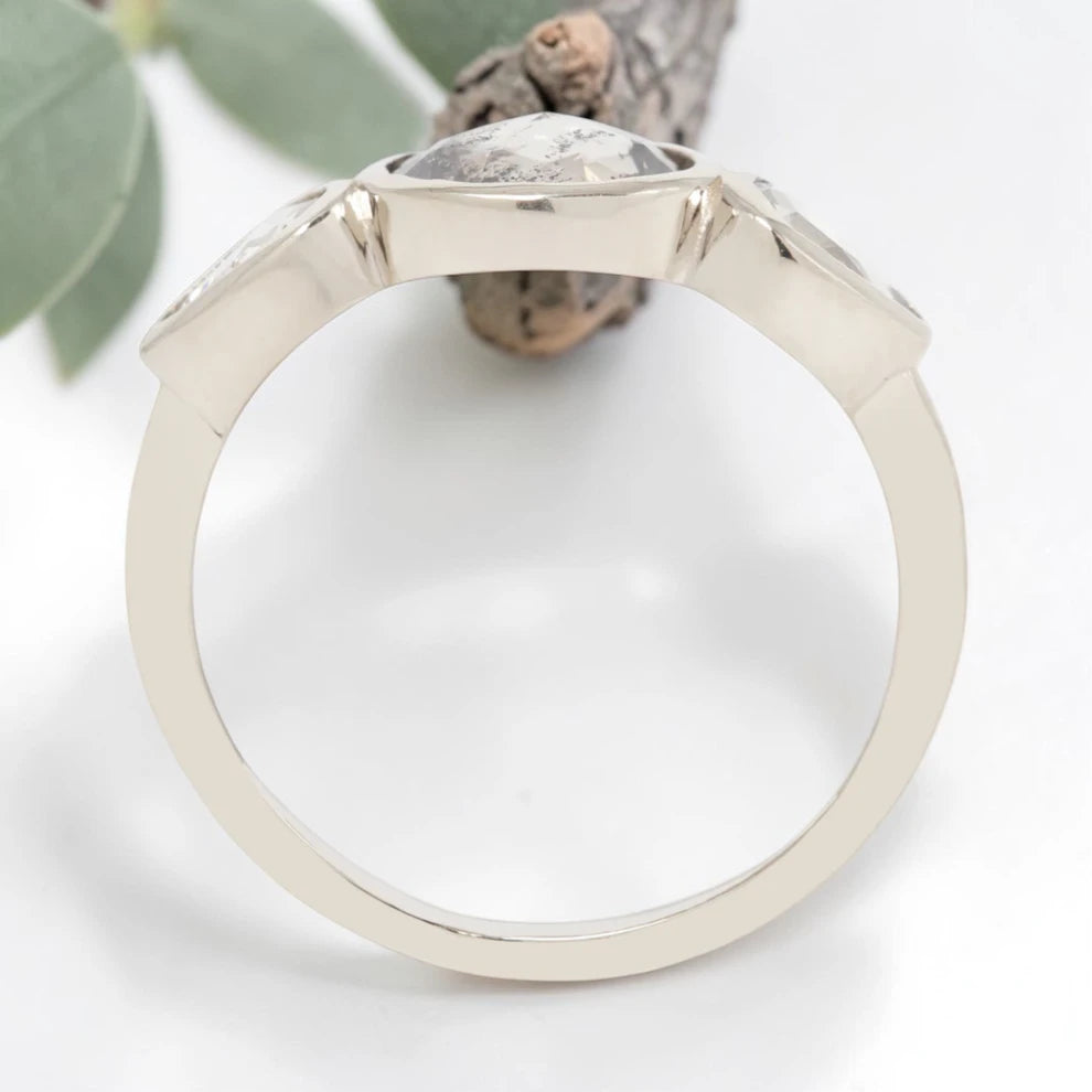 Oval cut salt and pepper diamond engagement ring featuring a 2.50 CT natural center stone with pear shaped side diamonds, set on a handcrafted knife edge band in a modern vintage fusion design.