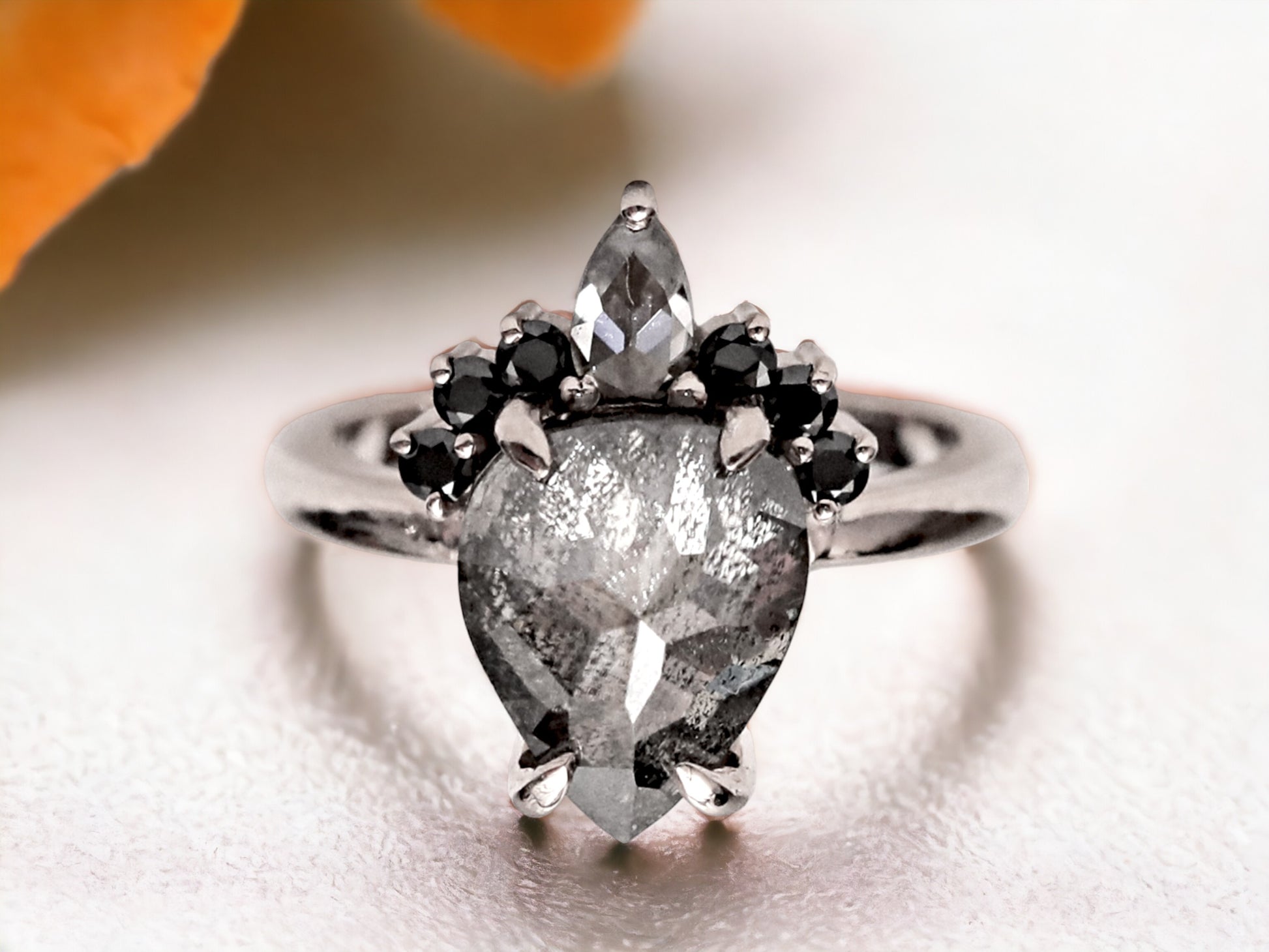 Rose Pear Cut Salt and Pepper Diamond Ring featuring a 3.56 CT natural salt and pepper diamond with smoky galaxy-like inclusions, accented by pear cut and round diamonds in a handcrafted alternative engagement design with a straight 2.30 mm band and modern, elegant aesthetic.