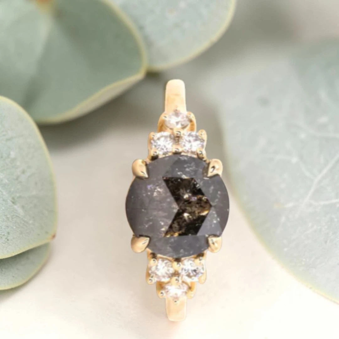 Round Rose Cut Salt and Pepper Diamond Cluster Engagement Ring featuring a 2.31 CT natural black salt and pepper diamond with unique inclusions, surrounded by six round accent diamonds on a handcrafted straight band design.